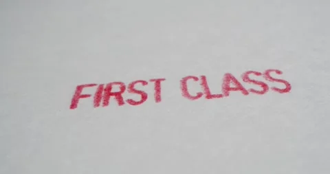 A stamp FIRST CLASS is placed on a sheet of white paper, close-up Stock Footage 251589488