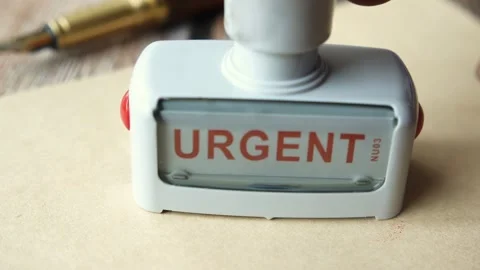Stamp marking urgent text on document with red ink closeup motion shot for .. Stock Footage 332785535