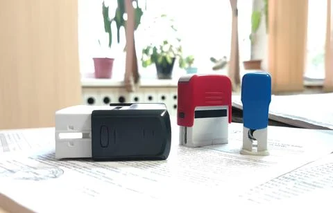 The stamp for office documents is black, red and blue on the table on paper Stock Photos