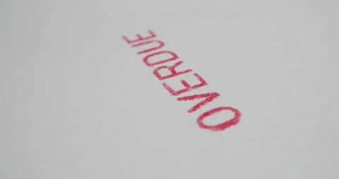 A stamp OVERDUE is placed on a sheet of white paper, close-up Stock Footage 251589307