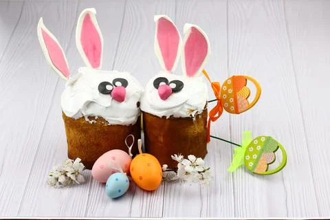 Stand with Easter cake, painted eggs and bunny on wooden background Stock Photos