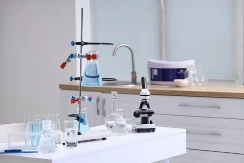 Stand with flasks of water samples and microscope on table in laboratory Фото