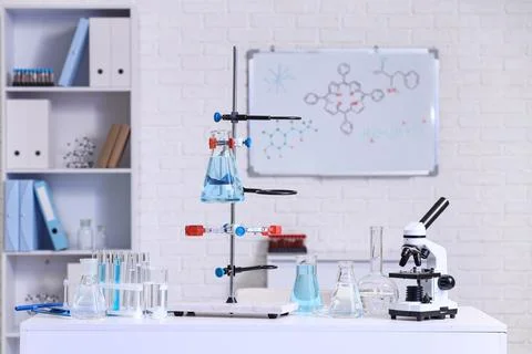 Stand with flasks of water samples and microscope on table in laboratory Фото