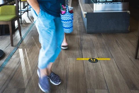 STAND HERE foot sign or symbol on wooden floor in coffee shop. Coffee shop se Stock Photos