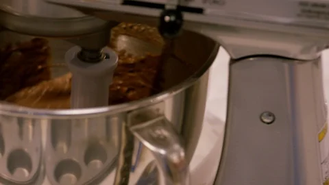 Stand mixer and flat beater making chocolate cake batter in bowl A Stock Footage 111677756