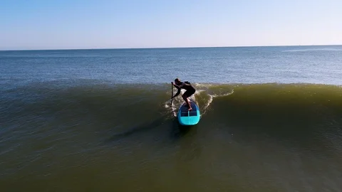 Stand Up Paddle Boarder Catching Wave Aerial Shot Video stock 117054893