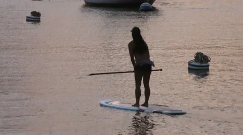 Stand up paddle boarder floating into amazing golden sunset in harbor.mp4 Video stock 67490049