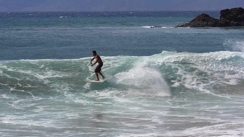 A stand-up paddle boarder rides a wave on the Kaanapali Coast, Maui, Hawaii. Stock Footage 107325778