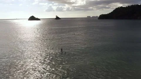 Stand up paddle boarder (SUP) at sunset with island silhouettes, aerial 4K Stock Footage 139501876