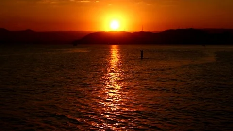 Stand up paddle passing on the beach with sunset in the background. Stock Footage 123979122