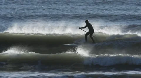 Stand Up Paddle Surfer Riding a Wave with Spray Stock Footage 12360297