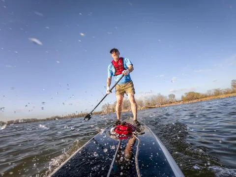 Stand up paddleboard making splashes on lake Stock Photos