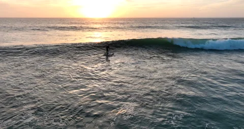 Stand-up paddleboard surfing during sunset in Ericeira, Portugal. Drone shot of Stock Footage 280130394