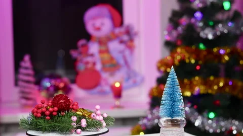 On a stand with rotating decorations near a small blue Christmas tree Video stock 257659603
