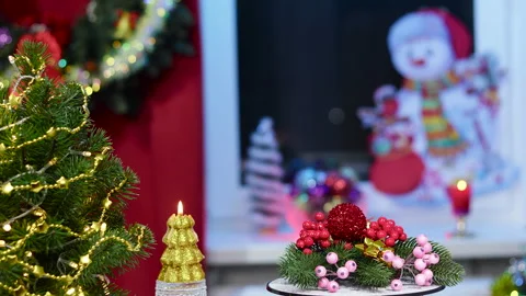 On a stand with rotating decorations near a small Christmas tree Stock Footage 257659613