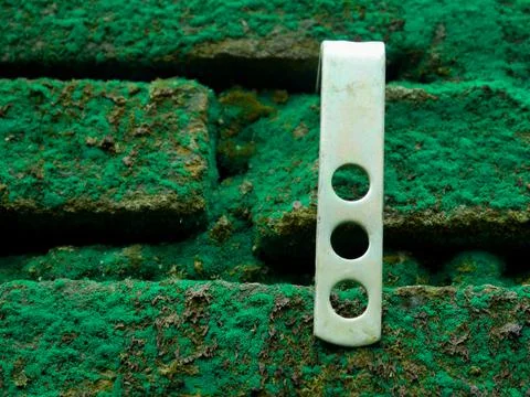 Stand wall clamp affixed on brick green wall for tool presentation. Stock Photos