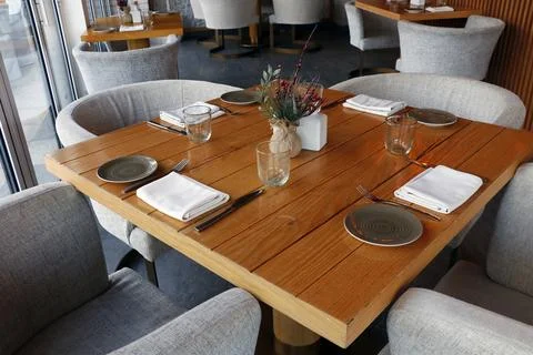 Standard dining table set up for the restaurant with wooden furniture Stock Photos