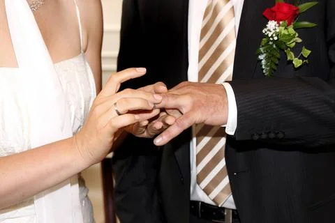 Standesamtliche Hochzeit, Braut steckt dem Braeutigam den Ehering an civil... Stock Photos