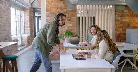 Standing African American man approaching loft desk with laptops, checking in Stock Footage 337944475