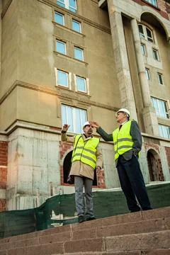 Standing and explaiing something about the plans Stock Photos