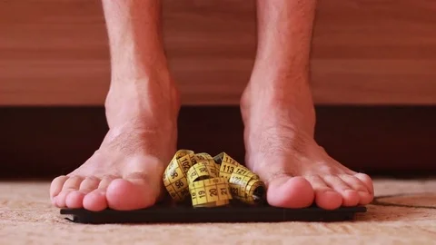 Standing barefoot on scales and taking tape centimeter Vídeos de archivo 82683431