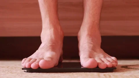 Standing barefoot on scales closeup Stock Footage 82683363