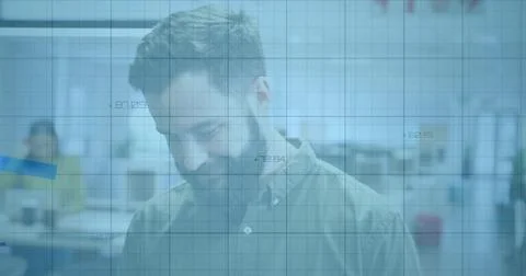 Standing bearded man in button-down shirt looking down at open-plan office, with Stock Photos