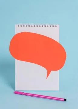 Standing blank spiral notepad speech bubble above pen lying cool pastel retro Stock Photos