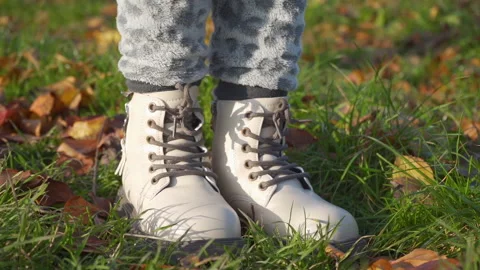 Standing in boots on grass with leaves Video stock 297487304