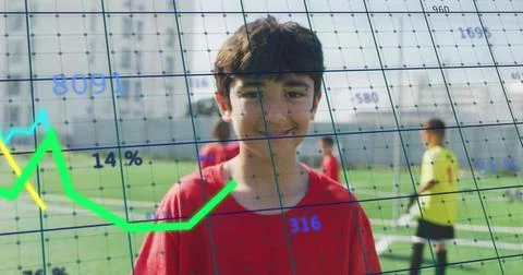 Standing boy in red jersey facing camera on grassy field, showing data overlay Stock Photos