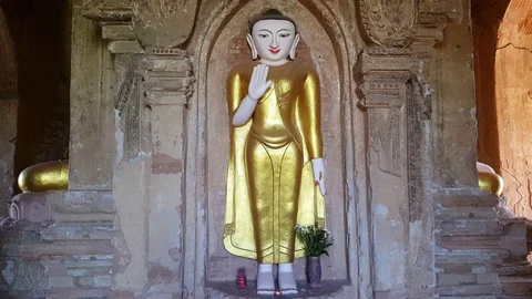 Standing Buddha statue inside Pagoda, seated Buddhas knees, golden gown, Bagan Vídeos de archivo 78665491