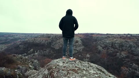 Standing on the edge of a cliff, looking into the distance Video stock 99938968