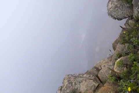 Standing on the edge of a cliff on the rocks you can see fog, and below you can  Stock Photos