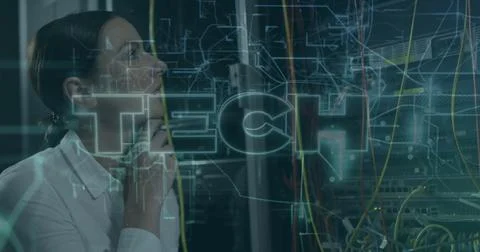 Standing female network engineer checking racks and cables in server room, TECH Stock Photos