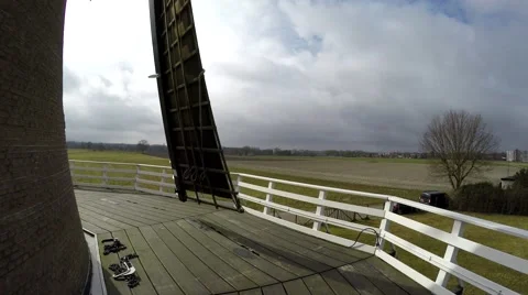 Standing at first floor of dutch windmill sails moving by wind at steady pace 4k Stock Footage 61396380