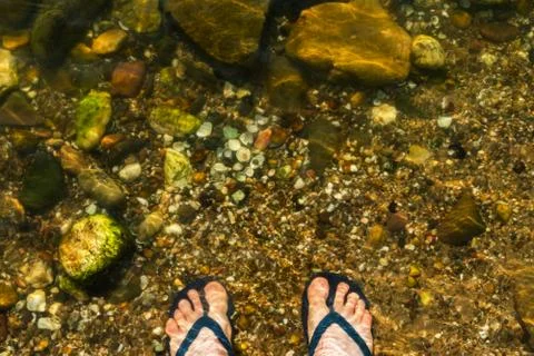 Standing in flip flops in a river Foto stock