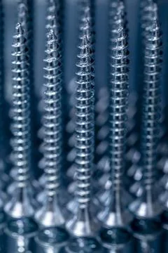 Standing galvanized self-tapping screws on a mirror surface Stock Photos