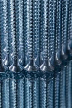 Standing galvanized self-tapping screws on a mirror surface Stock Photos