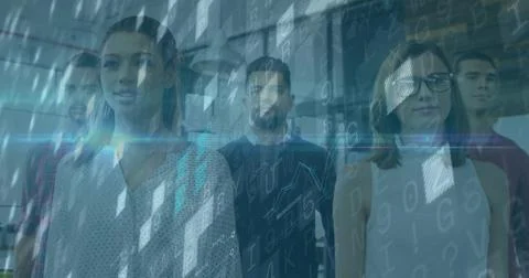 Standing group of software professionals examining digital code overlay in 库存照片