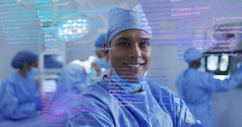 Standing Hispanic surgeon smiling at camera in operating room, blending code  Foto stock