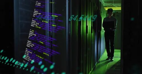 Standing Korean IT tech in dark uniform checking laptop at server aisle, Stock Photos