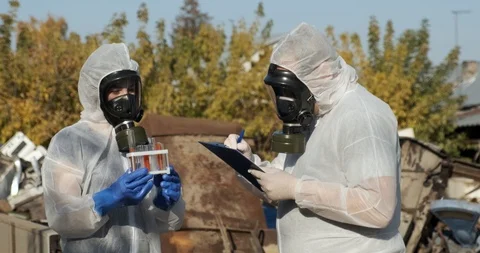 Standing in landfill, notes of results, knocks tubes to ground, idiots at work Stock Footage 119052627