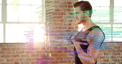 Standing male coder with glasses, dark tee interacting with code display in loft Foto stock