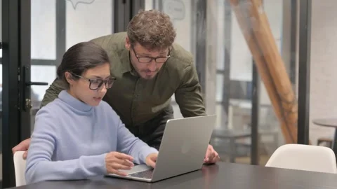 Standing Man Discussing Work on Laptop with Female Worker Video stock 307223438