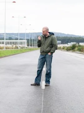 Standing man lighting a cigarette Stock Photos