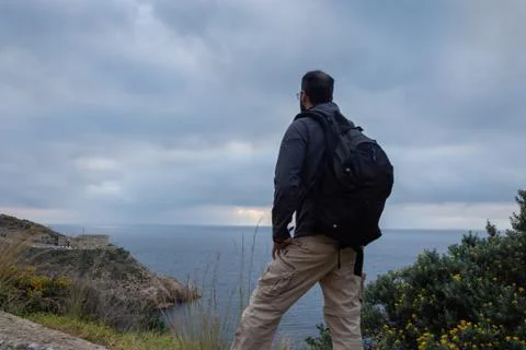Standing man observing the landscape on a cloudy morning Stock Photos
