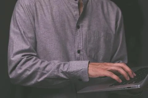 A standing man using a laptop computer Stock Photos