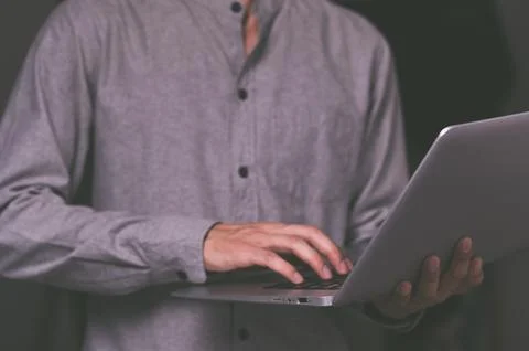 A standing man using a laptop computer Stock Photos