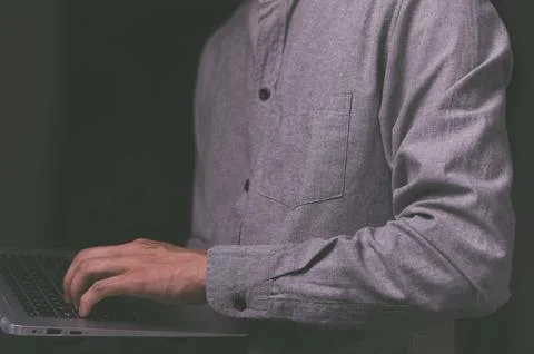 A standing man using a laptop computer Stock Photos