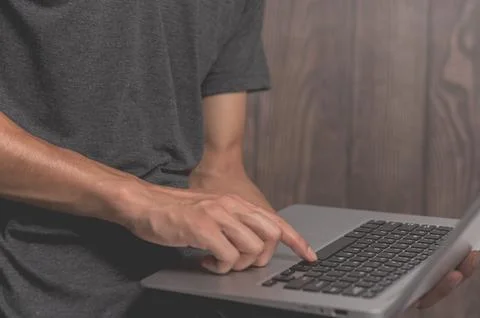 A standing man using a laptop computer Stock Photos